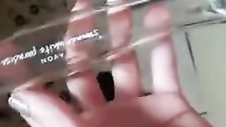 Chica mete una botella de perfume en su coño afeitado y los toca