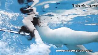 Chica desnuda flota bajo el agua y brilla un coño sin afeitar en la piscina