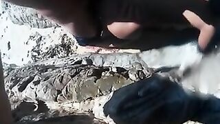 Perra chupa polla y folla cáncer con un amante en la orilla rocosa junto al mar